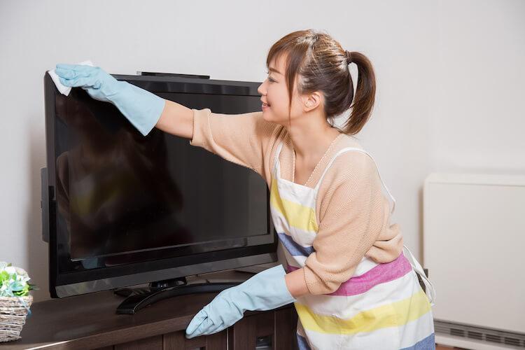テレビを掃除する女性
