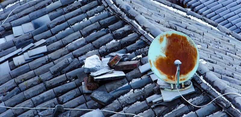 錆びたアンテナと壊れた瓦屋根